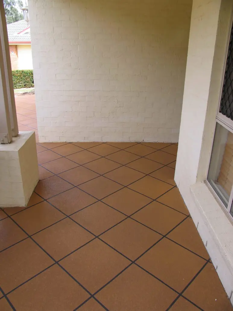 Red-brown speckled concrete tile pattern with dark charcoal grout lines