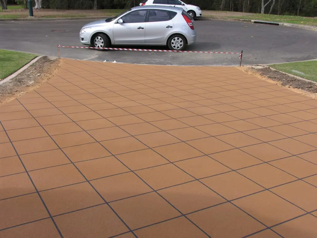 Tan decorative concrete driveway with charcoal grout lines in a diamond tile pattern