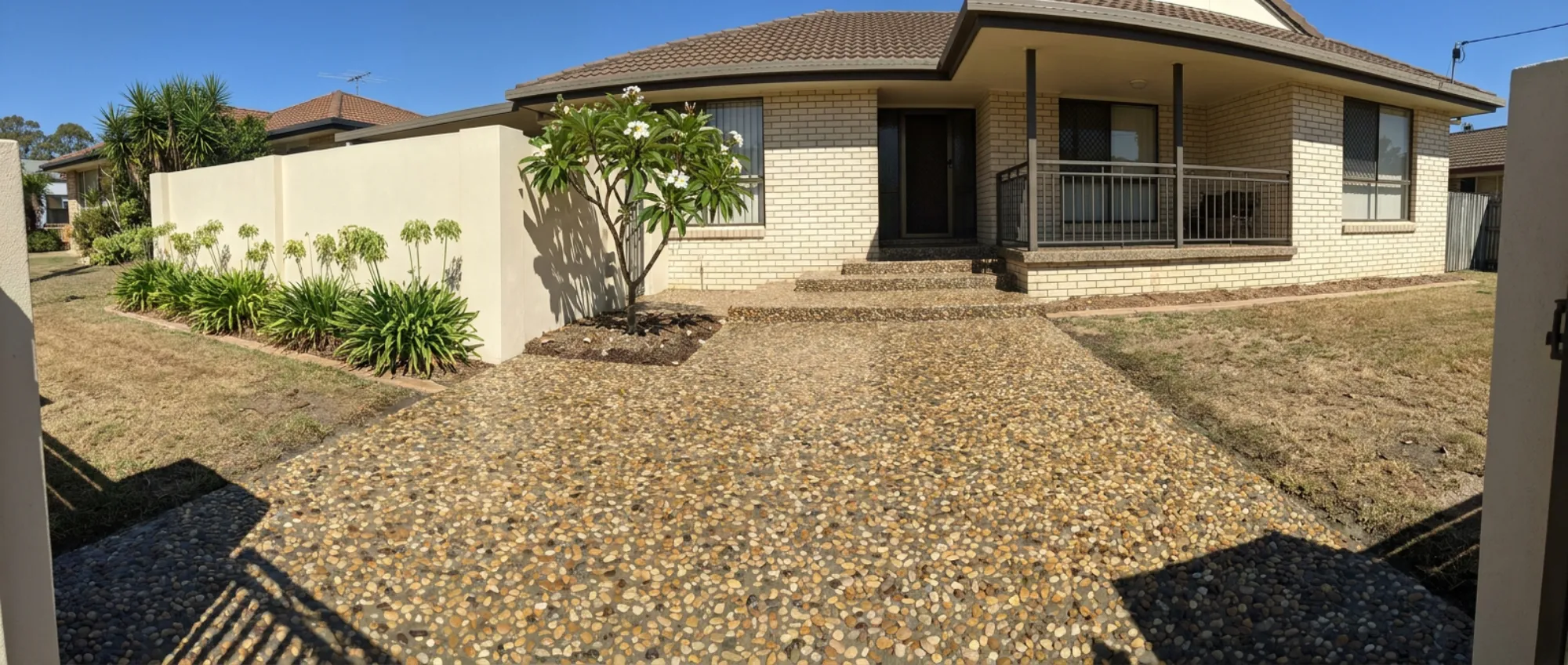 Exposed aggregate concrete steps and entry path of honey and brown river pebbles sealed to a wet look