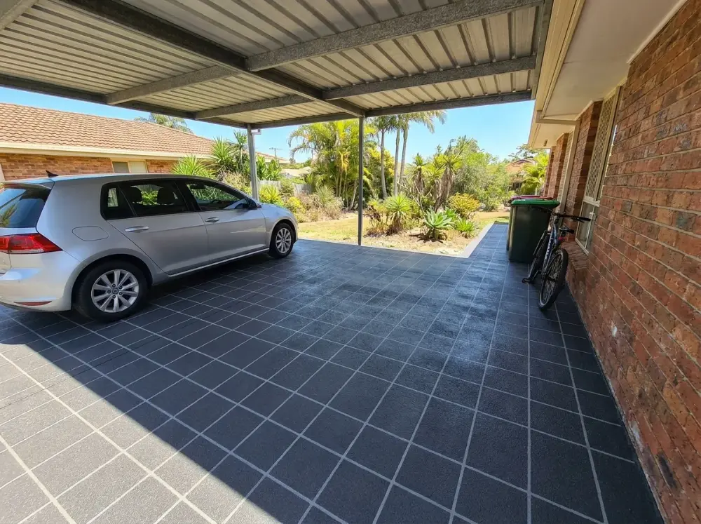 Double carport floor resurfaced in a charcoal square-tile pattern with pale grey grout lines