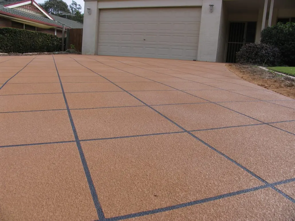 Close-up of a resurfaced concrete surface showing the fine sandy speckle of the overlay and a crisp grout line