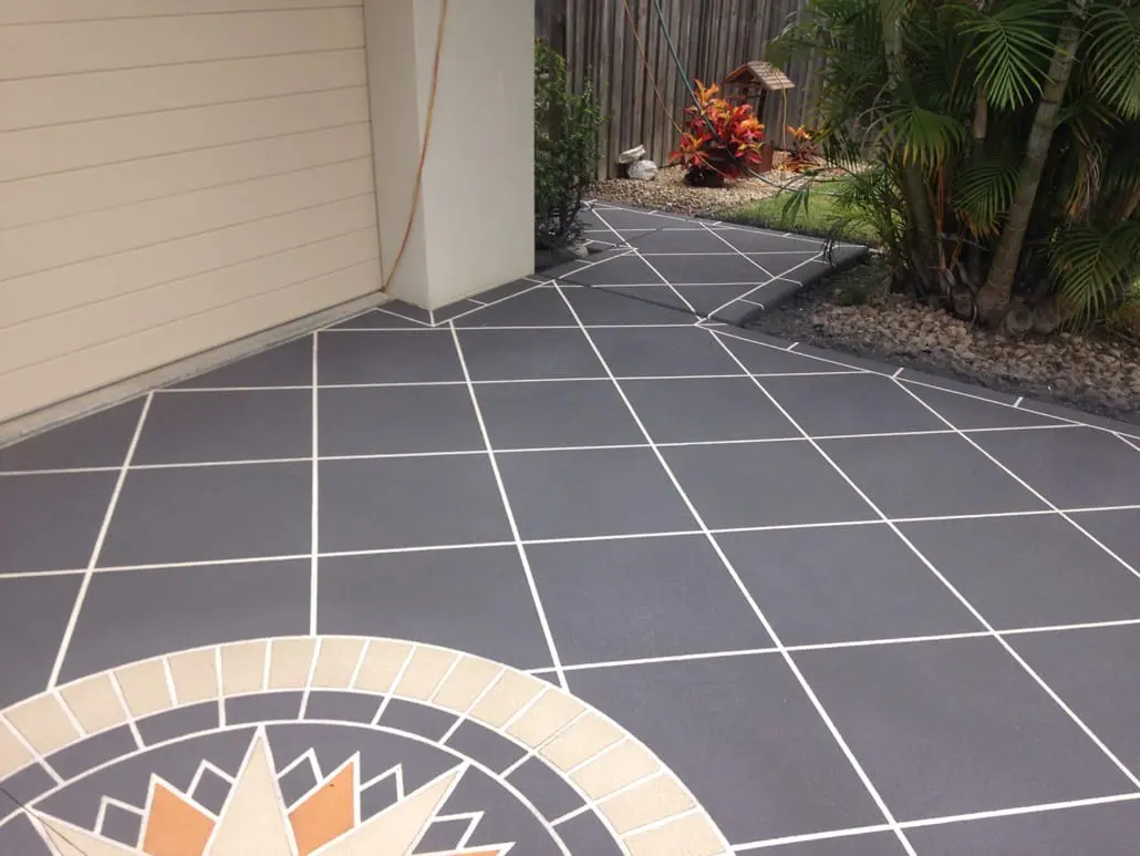 Charcoal decorative concrete driveway with crisp white grout lines and a custom sunburst star motif, laid by Brisbane Concrete Resurfacing